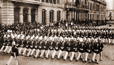Cadetes del Colegio Militar desfilan frente a la casa de gobierno en un 25 de mayo de 1920